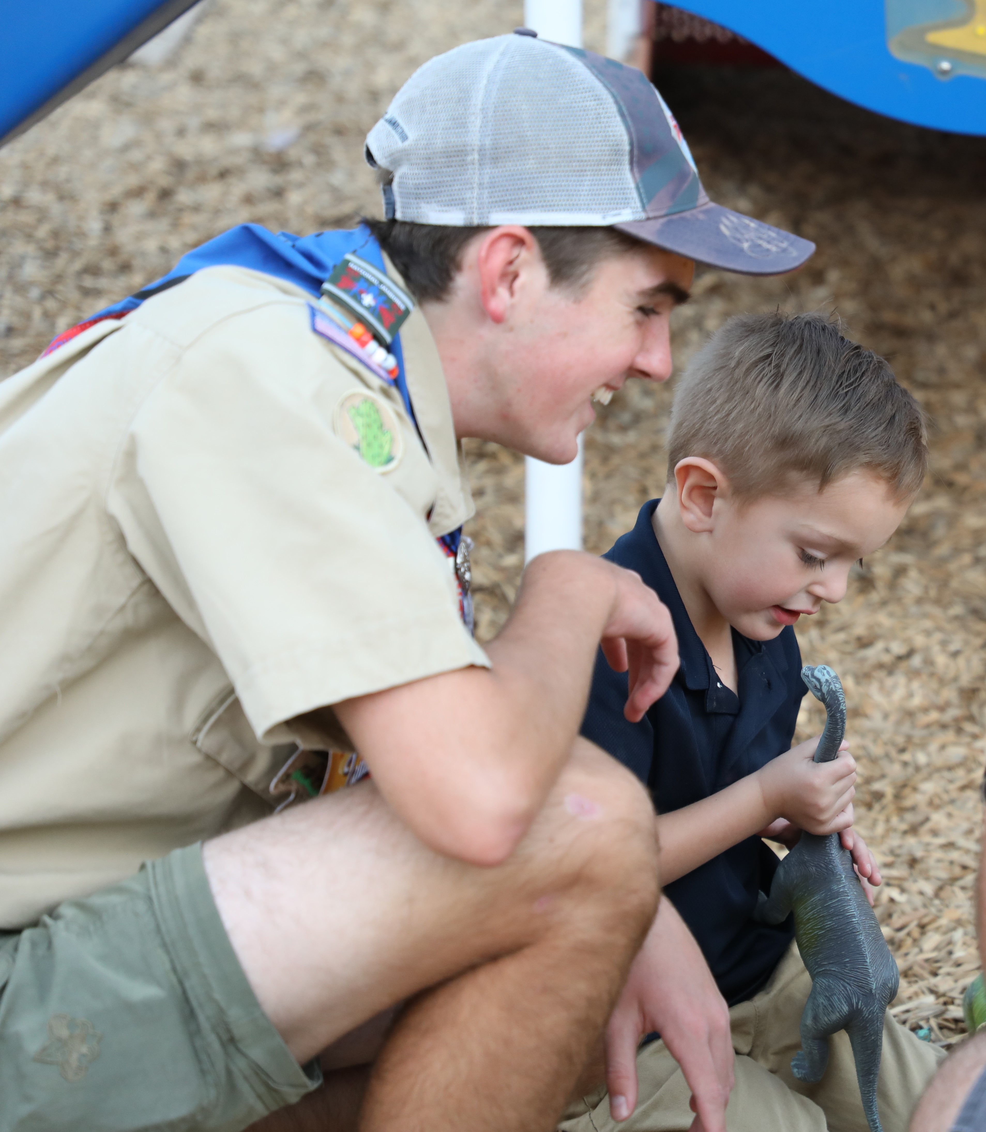 Image of Luke Fulton smiling with Lil' Explorers student in front of planters